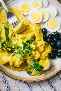 a plate with eggs, cheese and black olives