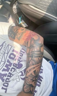 a man with tattoos on his arm sitting in a car