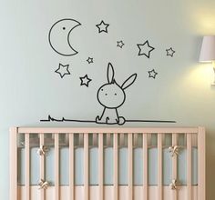 a baby's room with a crib and wall decal in the shape of a rabbit