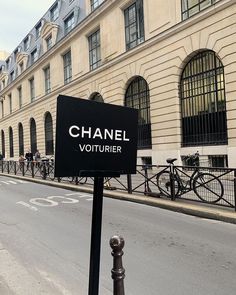 a street sign in front of a building with bicycles parked on the side of it