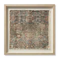 an old rug with faded colors and designs in a wooden frame on a white wall