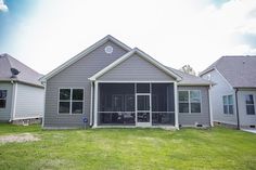 a house that is in the middle of some grass and has two windows on each side