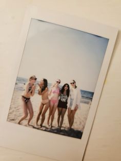 a group of women standing next to each other on a beach