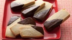 several pieces of chocolate and vanilla shortbread on a red plate with pink tablecloth