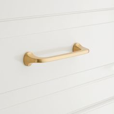 an image of a brass handle on a white cabinet door with horizontal lines in the background