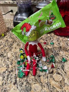 an elf is holding a bag of kleene's candy on the counter