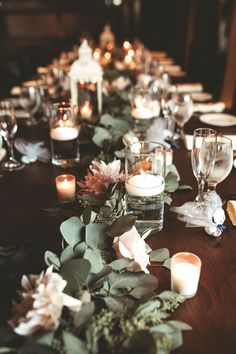 the table is set with candles, flowers and napkins for an elegant dinner party