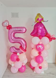 two large balloons with the number five on them are in front of a white wall