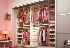 an organized closet with pink walls and white carpeted flooring in a child's bedroom