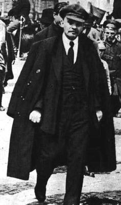 an old photo of a man in a suit and tie walking down the street with other people