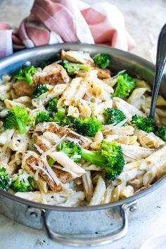 a pan filled with pasta and broccoli on top of a table