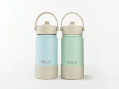 two water bottles sitting next to each other on a white surface with the words cruze and beau printed on them