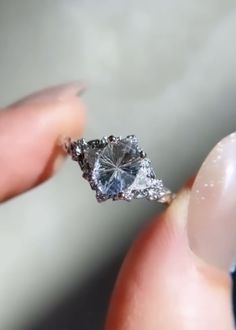 a person holding a diamond ring in their hand