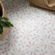 a potted plant sitting on the floor next to a white and beige tiled floor