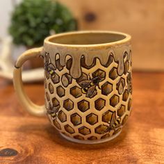 a ceramic mug with honeycombs and bees on it