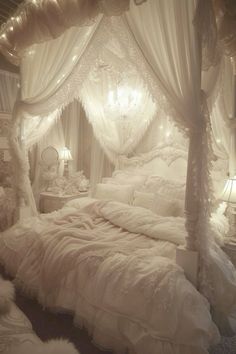 a white bed sitting under a chandelier next to a night stand with lights on it