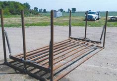 an old metal bed frame sitting in the middle of a dirt field next to a truck