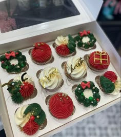 twelve decorated christmas cupcakes in a white box