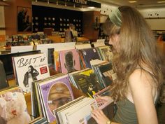 a woman looking at records in a record store