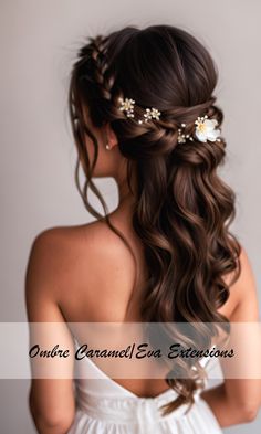 a woman with long brown hair wearing a white dress and flowers in her hair is looking back at the camera