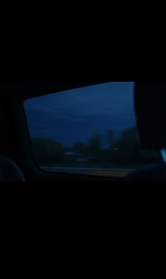 the view from inside a car at night with trees and sky in the back ground