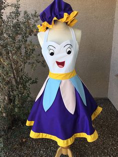 a dress made to look like a woman's head with a yellow ribbon around her neck