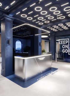 an office lobby with a reception counter and neon lights on the ceiling that are lit up