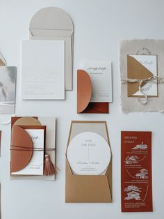 the wedding stationery is laid out on top of each other, including cards and envelopes