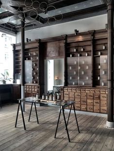 an empty room with wooden shelves and metal objects on the tables in front of it