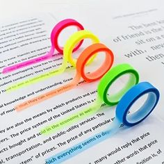 five different colored rings sitting on top of an open book