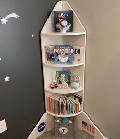 a corner book shelf with books on it in a child's playroom area