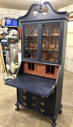 an antique china cabinet with glass doors and drawers on wheels in a shop setting,