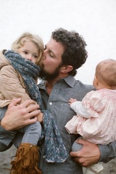 a man kissing a woman while holding a baby