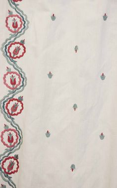 an embroidered white cloth with red and blue flowers