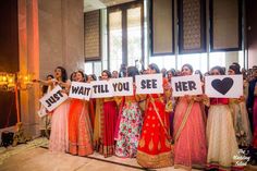 a group of women holding up signs in front of a crowd at a wedding ceremony