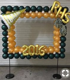 an image of a balloon arch with balloons and streamers on the top, in front of a garage door