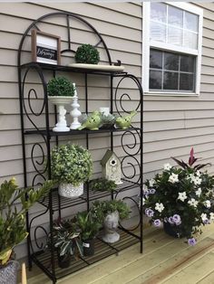 an outdoor shelf with potted plants on it