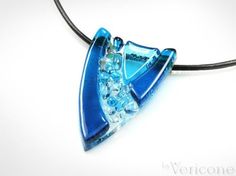 a blue glass pendant is hanging on a black cord