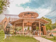 people are standing outside in front of a wooden structure that is made out of bamboo