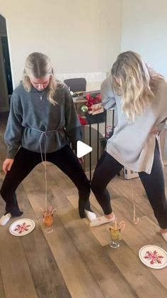 two women standing on top of a wooden floor