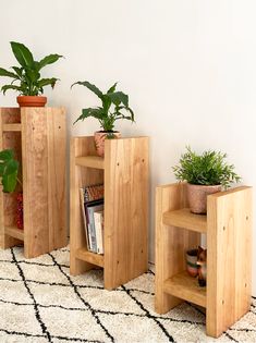 three wooden planters with plants in them on a rug next to a white wall