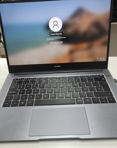 an open laptop computer sitting on top of a white table next to a mouse and keyboard