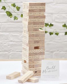 a stack of wooden blocks sitting on top of a table next to a potted plant