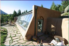 an adobe - style house with large glass windows on the roof