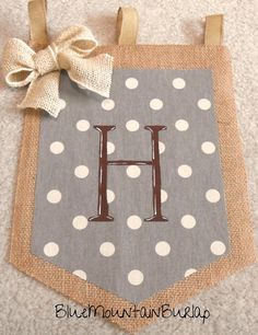 a gray and white polka dot banner with the letter h on it