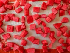 watermelon cubes are cut up on a cutting board