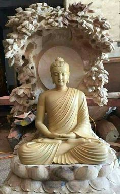 a buddha statue sitting on top of a pile of rocks