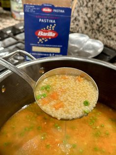 a ladle full of soup is being held over the pot