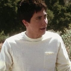 a young man holding a frisbee in his right hand and looking off to the side