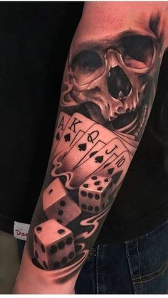 a man with a skull and dice tattoo on his arm, holding two dices